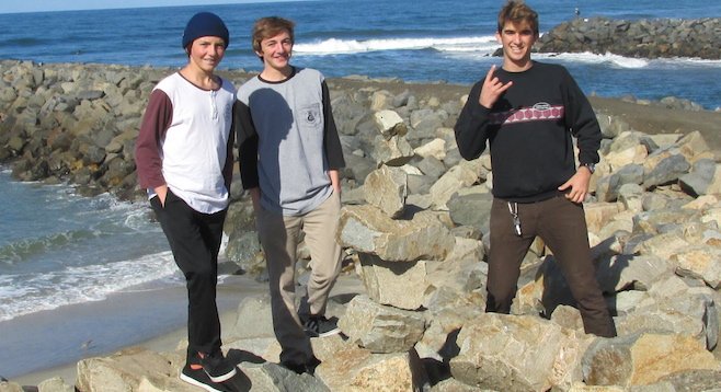 Carlsbad High's Noah Simpson, J.P. Simpson, and Cole Troya build the season's first rock sculpture near Tamarack beach.