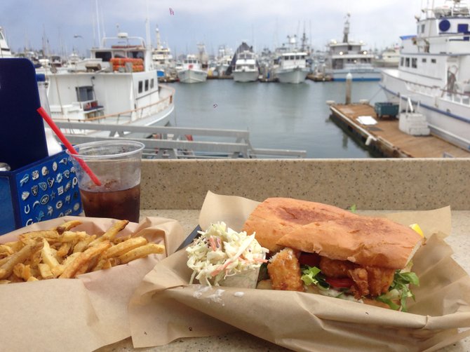 Tasty sandwich, fries and boats. Beer battered fish sandwich. Mitch's Seafood.
