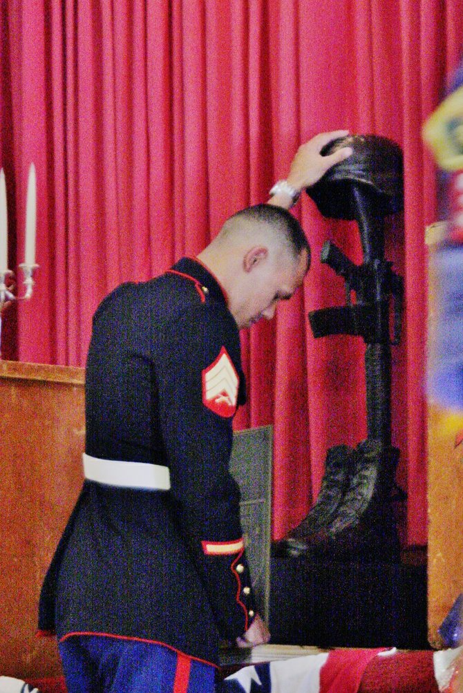 Marine in prayer to a fallen comrade.