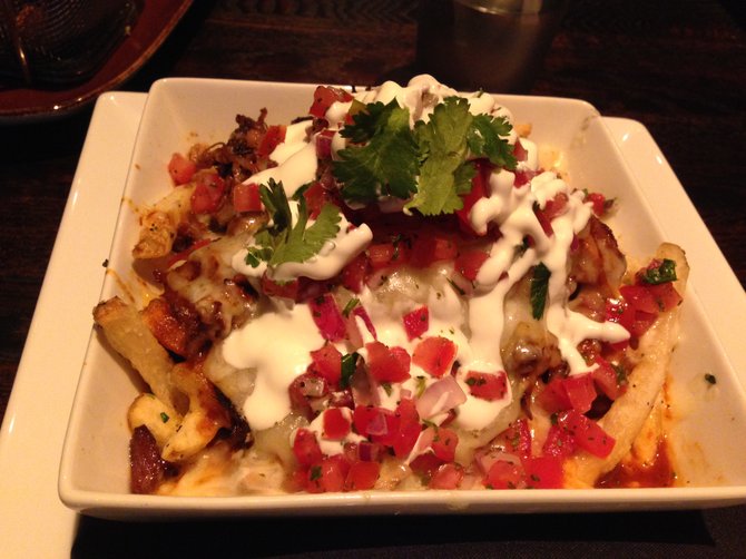 Saltbox's SoCal Poutine has carnitas, salsa rona and manchego cheese over french fries.