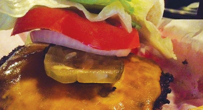 Crunchilicious burger patty with crispy-fresh onions and pickles, lettuce, and tomato