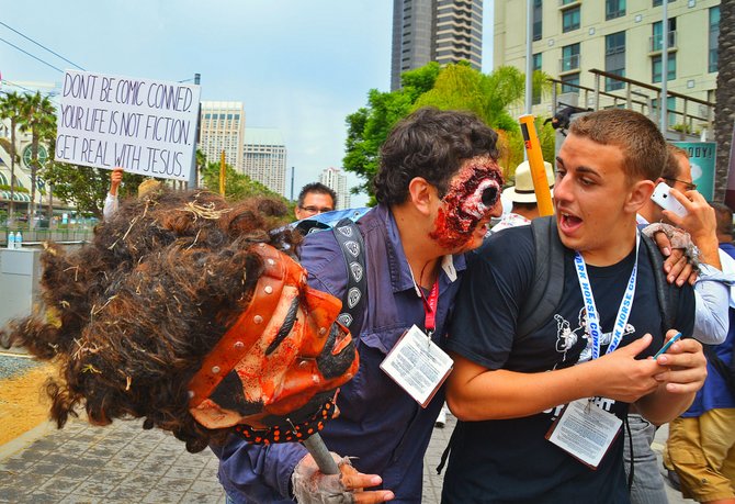 A costumed Comic Con attendee sneaks up his friend.
