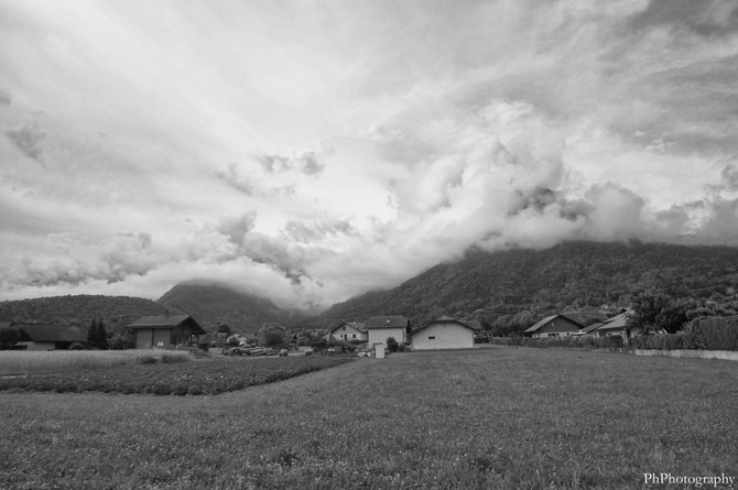 A small farm just outside of Annecy, France, with the French Alps in the background on just after a stormy day.