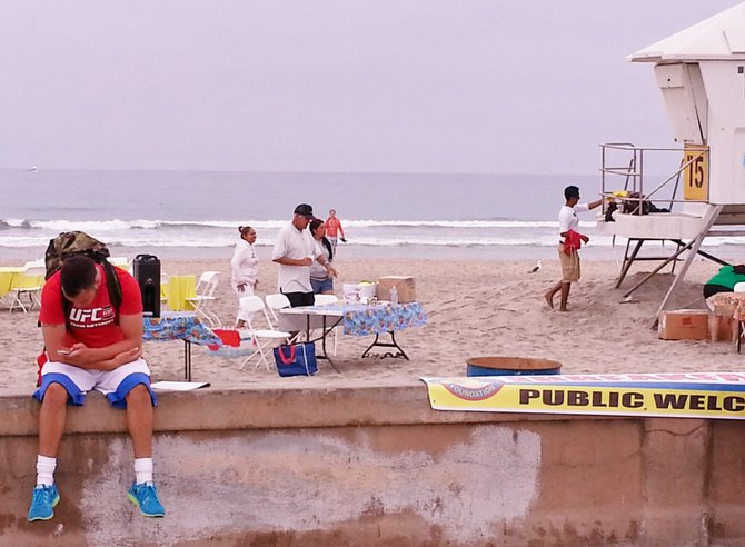 A backpacker awaits breakfast as Junior Lifeguards prepare for the morning's events