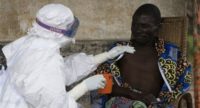 A health worker tends to a man with the Ebola virus