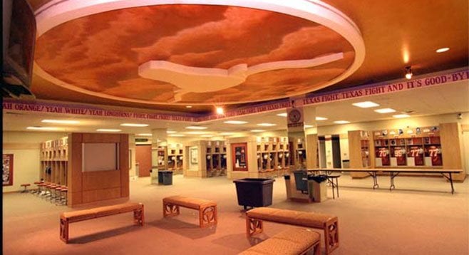 University of Texas locker room, where the team is valued at $139 million and coach’s salary is $5 million