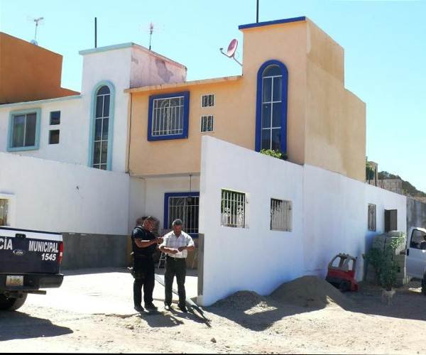 Investigators outside home where gruesome discovery was made. (Photo: El Sol de Tijuana)