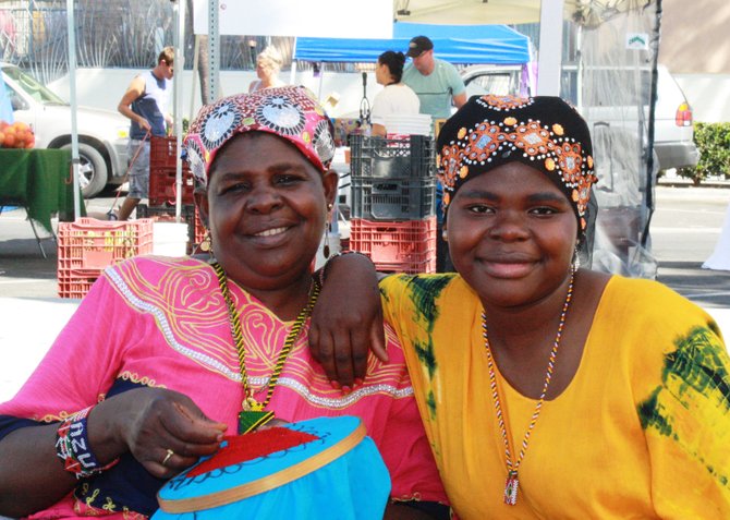 Khadija Musame and Madina Mah take a break from their produce stand to pose for a photo