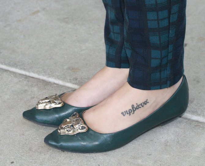 Nehme paired green lion flats with a Nirvana tattoo