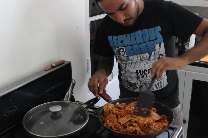 Iván stirs the "Red Monarch" chilaquiles based on his grandmother's recipe. 