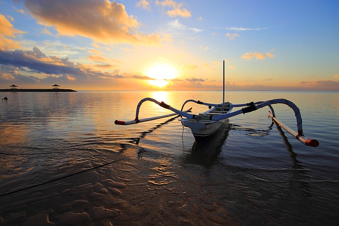 A jukung (Indonesian outrigger) in the calm water at sunrise in Sanur. I took this photo on our 2-week vacation to Bali in May of last year.