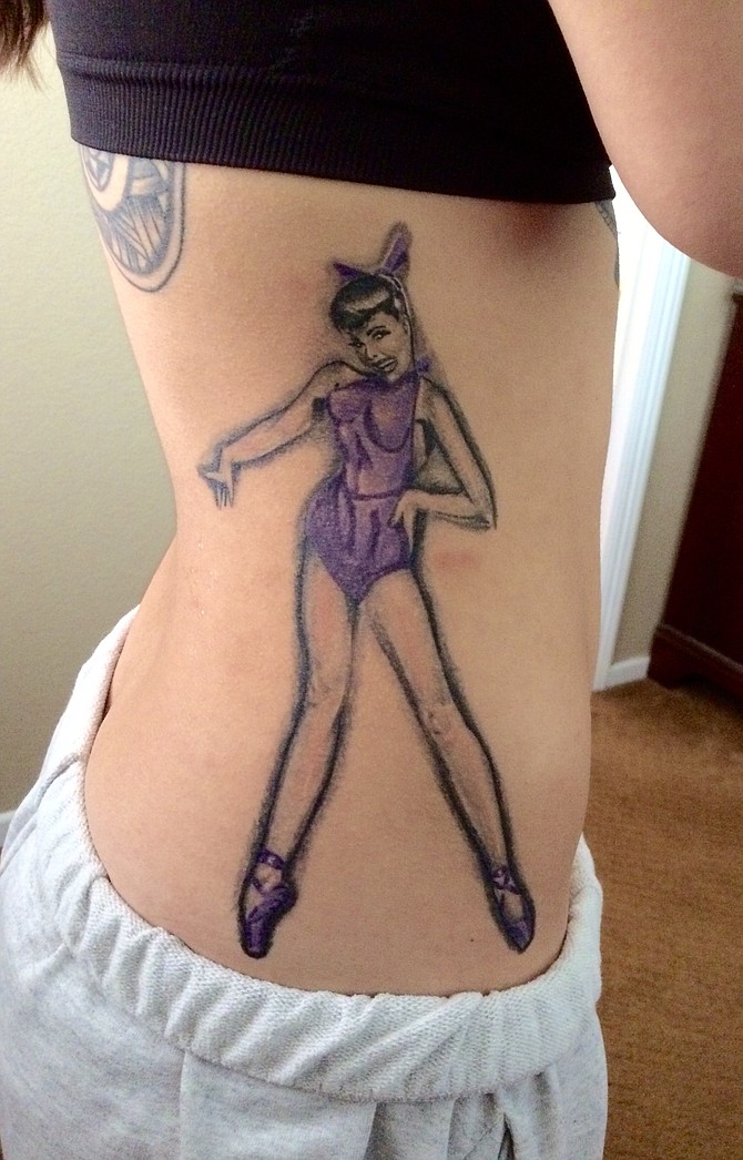 Im 19 and live in Chula Vista.
This was my 14th tattoo, that expresses the love I have for dance. 
It is another amazing black/grey portrait of a pin up girl on pointe shoes. The highlighted color is purple because it's my favorite. I am a professional dancer/choregrapher with Dark Horse Dance Productions and also an employee at Step It Up Studios. Life is all about taking chances, doing what you love, and what makes you happy. That's exactly what I chose to do with mine.
Artist: Jesus Sanchez
Shop: Wylde Sydes Tattoo 