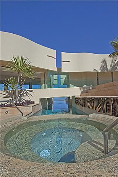 The pool passes under the house to another entertainment area.