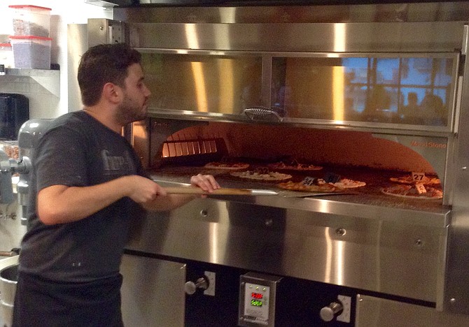 George manages quick-bake pizzas in 550-degree oven