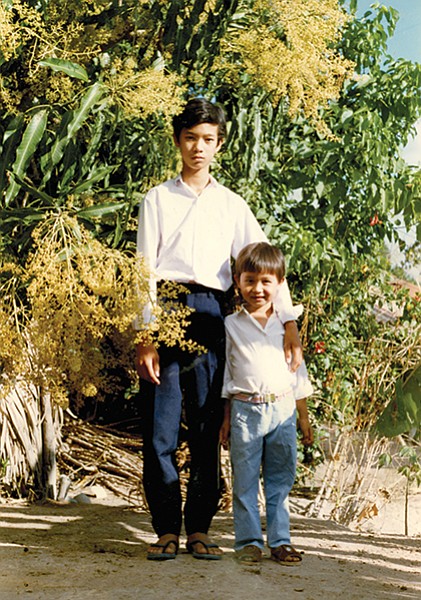 Tam with his older brother in their village. After my brother died, my mom received offers from people offering their children to pretend to be him so that their child can come to America with us.