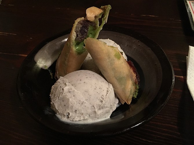 Black sesame ice cream with green tea and red bean spring rolls, earthy-sweet. 
