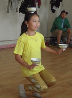11-year old dancer in Nalaikh, mining town NE of UB.  Those bowls are full of water and must not spill.