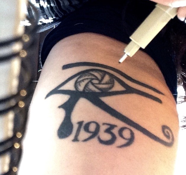 My tattoo is a customized version of the Ancient Egyptian symbol Eye of Ra. It is an ode to my grandfather, a photographer born in 1939. The idea is to remember his existence made a difference and not to dwell on his passing. The iris of the eye are the aperture blades of a camera lens, drawn using a cross hatching technique to keep the shading clean. I am 26 and new to San Diego from Chicago where I got the tattoo done. I take after my grandfather as photographer and work as a server downtown and in Hillcrest.