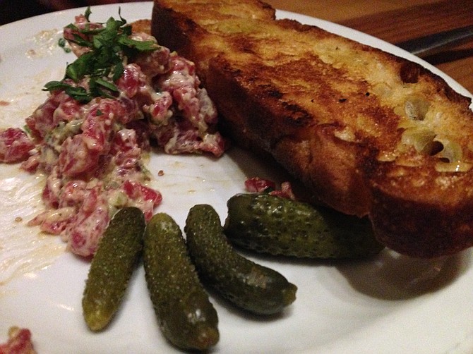 Making a dent in the steak tartare while the cornichons go relatively unnoticed.