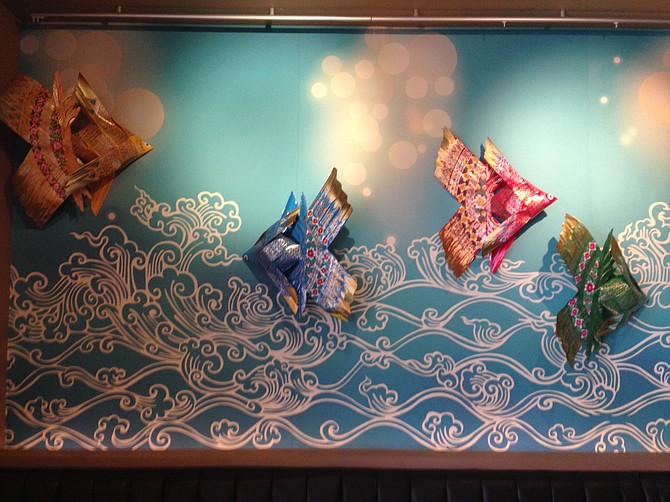 Coconut-leaf fish swimming in a sun-dappled ocean mural