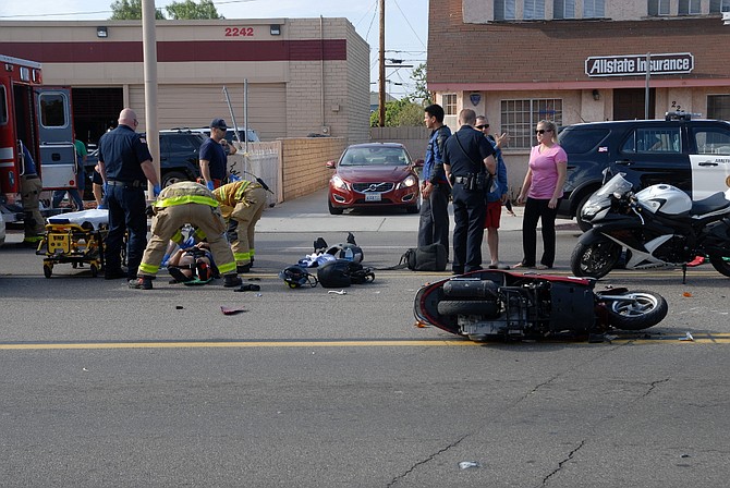 EMTs and firemen assisting the injured motorcyclist
