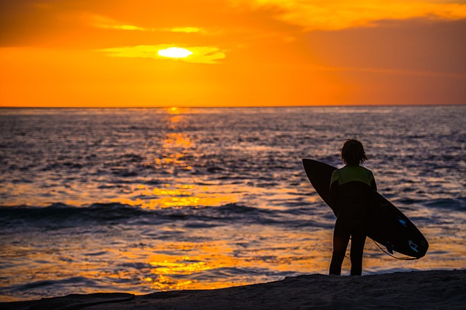 A candid of a young surfer at Windansea Beach under a beautiful San Diego sunset.