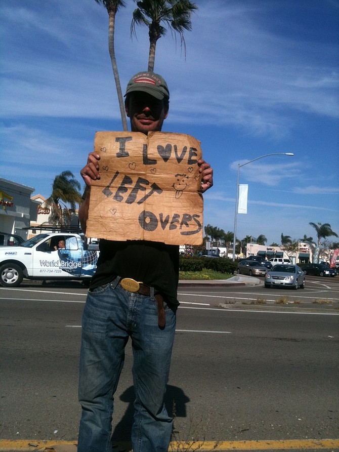 A lone beggar in Point Loma with one of the more lighthearted cardboard signs