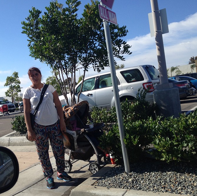 Woman begging with child in Target parking lot entrance in Clairemont on Friday, July 3, at 5 pm. She hid sign when she saw camera.