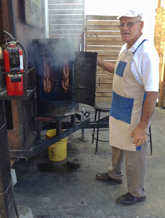 The chef’s dad  shows off the meat-smoking process