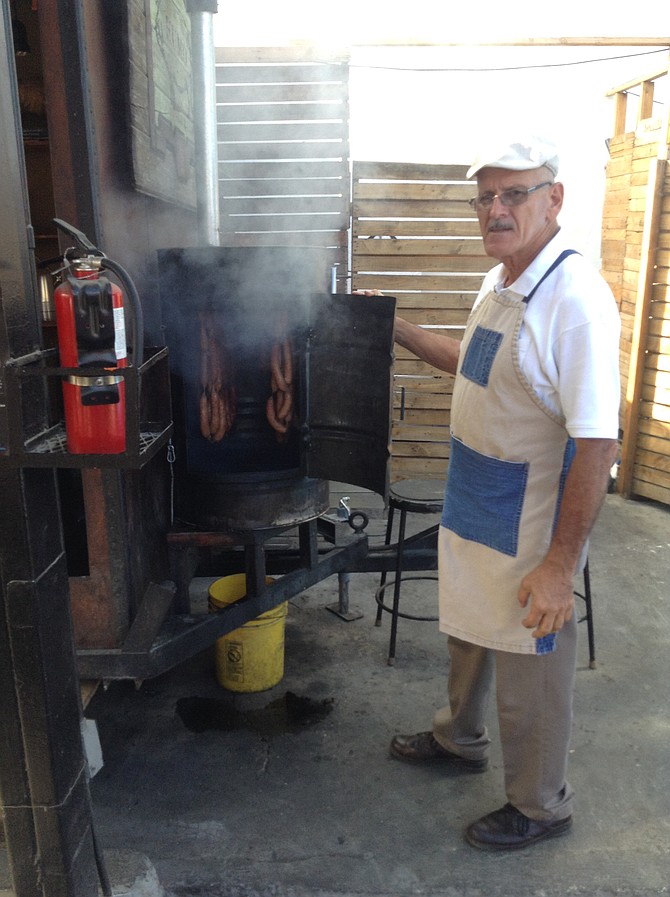 Giovanni's dad shows off the sausages being smoked