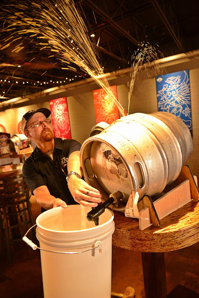 Brew Master Jason Stockberger at Mike Hess Brewery in North Park taps a feisty, fruit-fermented keg for the V.I.P tasting room at Hess Fest 2015. 