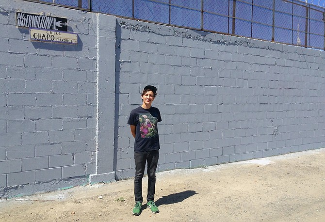 David Peña, standing next to the grey wall