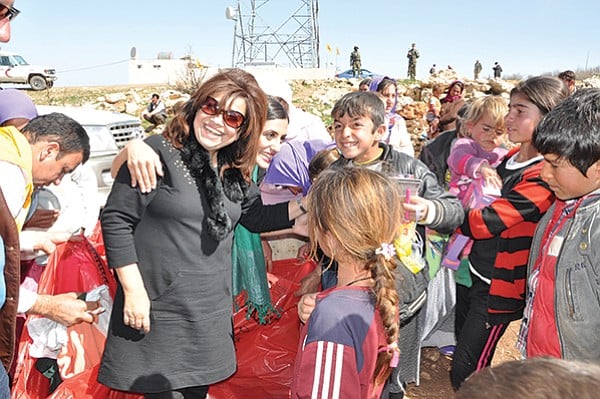 Yvette Isaac (center, wearing sunglasses) joins an elderly Yazidi woman in blessing gifts from Southern California