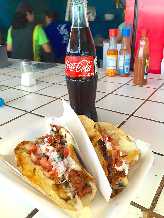 Two marlin tacos and a coke with kitchen view