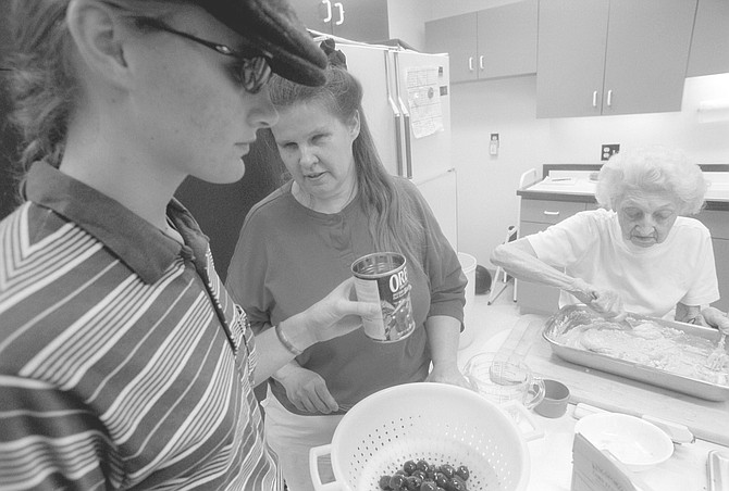 Linda (center) at cooking class. They taught the students how to prepare a spaghetti pie, salad, and spicy oatmeal cookies.