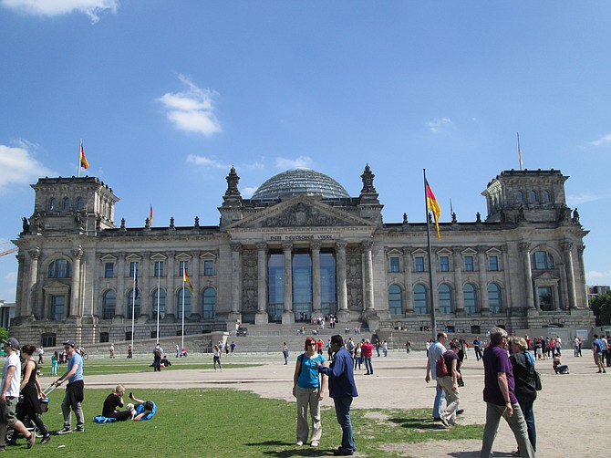 Tourists and sunbathers before the Reichstag building, Germany's seat of parliament.