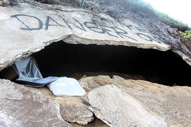 Police spraypainted “Danger Keep Out” above this cave carved into the bluffs at the foot of Orchard Avenue.