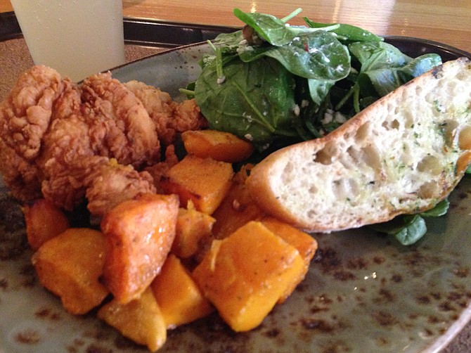 Boneless fried chicken served with roasted butternut squash, spinach salad, and slice of toast
