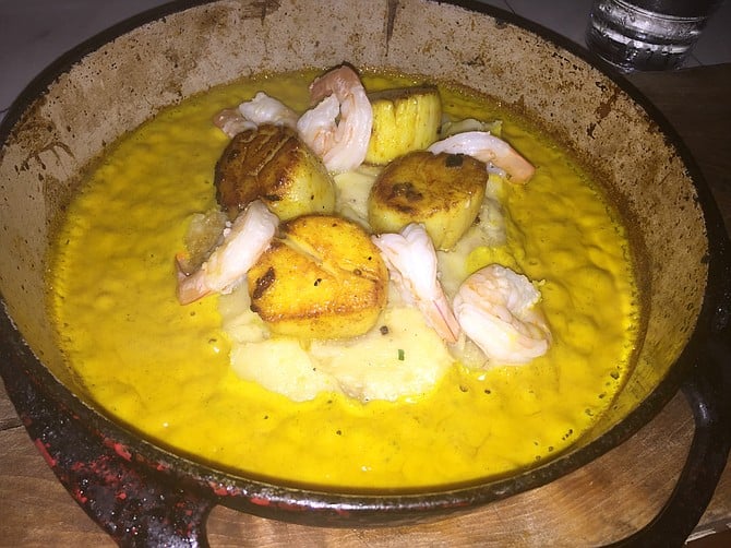Curried scallops with mashed potatoes and leeks in a cast-iron skillet