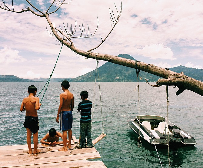 Boys out for a rope swinging swim in Lake Atitlan, Guatemala