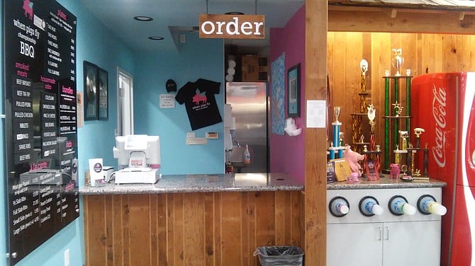 Food is ordered and served in this corner of the Chevron, with the winning trophies of the  owners standing next to the soda machine at When Pigs Fly. 