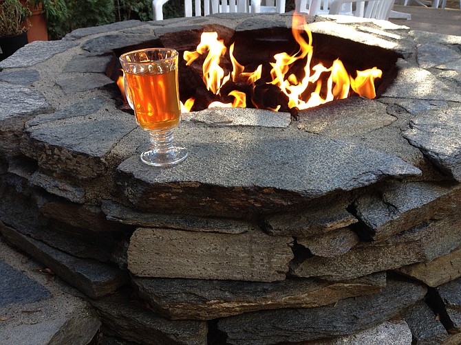 Warm apple cider beside a fire pit