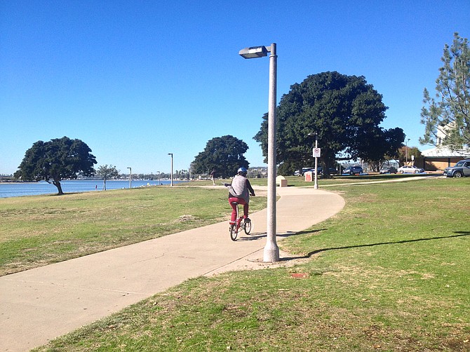 Cyclist riding along pathway along contamination site at Mission Bay Park