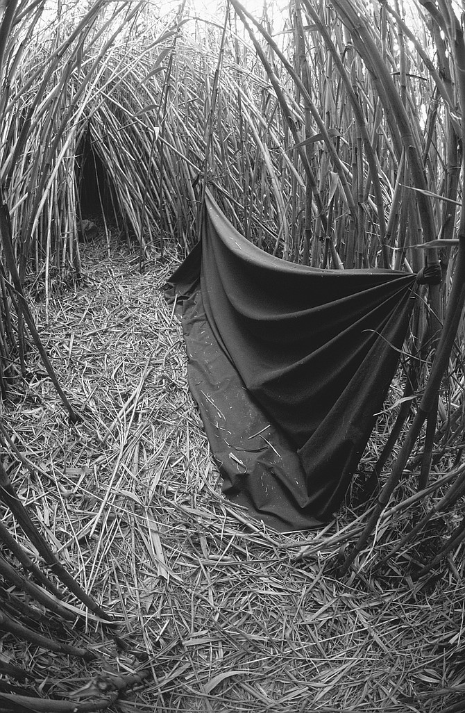 Along North River Road near Camp Pendleton are small, tentlike caves cut into the reeds; spanning the entrance to each hooch was a blanket or a plastic sheet.