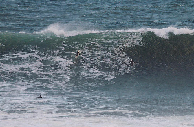 Surfers scratch over a set at the cove. Photo courtesy of Connor Kollenda