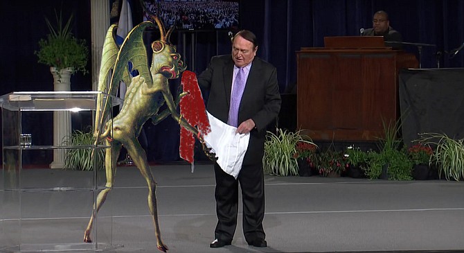 Happier Times: Beelzebub presents Cerullo with a prayer shawl soaked in the Blood of the Worthless Poor at a 2014 Prosperity Gospel Conference. “Back then, I thought we would go on and on,” recalls the disappointed demon. “You can’t see it in the photo, but my butt-face is smiling from cheek to cheek!”