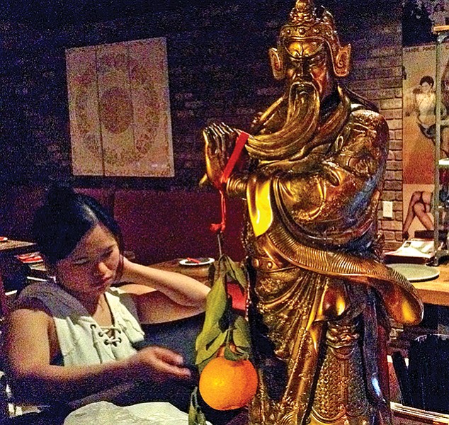 Inside Lucky Liu's, Confucius and a gift of an orange, a very auspicious Chinese New Year symbol of wealth, luck, and gold. Added significance: “Orange” in Chinese sounds like the Chinese word for “wealth.”
