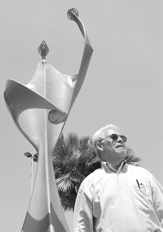 Julio Rodriguez, in front of a monument to the teachers of Tijuana, A car passes, stops, honks. Inside, two men wave and clap and call out the professor's name.