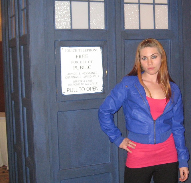 Kat Sky, posing next to the Tardis, potrays Rose Tyler from Doctor Who 