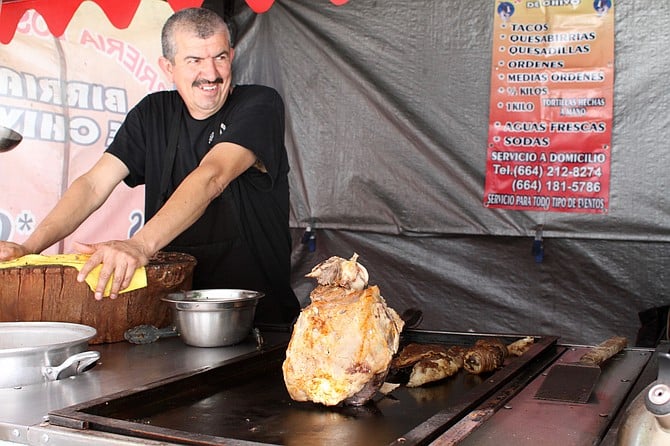 A huge goat leg and smiling taquero